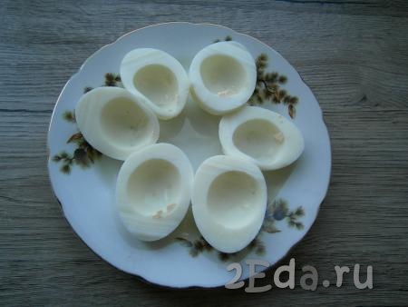 Каждое яйцо разрезать пополам, вынуть желтки. Выложить на блюдо половинки белков.