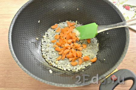 Очищаем морковку, нарезаем на тонкие полукружочки (или брусочки), добавляем к обжаренным луку с чесноком, перемешиваем. Обжариваем овощи минуты 3-4, периодически перемешиваем.