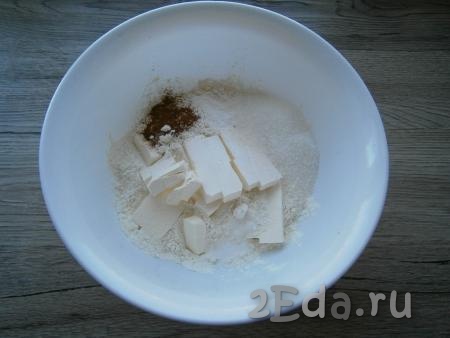 Для приготовления теста смешать в миске сахар, муку, соль, разрыхлитель. Добавить корицу и нарезанное кусочками холодное сливочное масло (или маргарин).