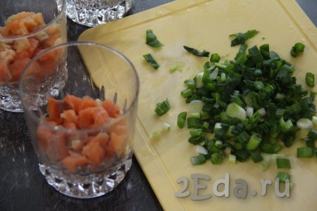 Зелёный лук вымыть и мелко нарезать. Салат будем выкладывать слоями. Можно выложить в один глубокий салатник или сделать порционную подачу в креманках или стаканах (я сделала порционную подачу, выкладывая салат "Королевская шуба" в 3 стакана). Первым слоем выложить рыбку, затем положить слой зелёного лука (если делаете порционную подачу, тогда равномерно раскладывайте ингредиенты по стаканам или креманкам).