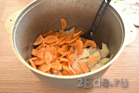 К обжаренной свинине добавляем нарезанные лук и морковь.
