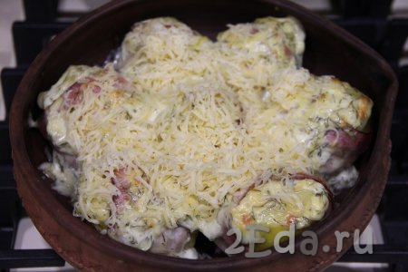 Посыпать картошку в беконе натёртым сыром и поставить обратно в духовку на 10 минут.