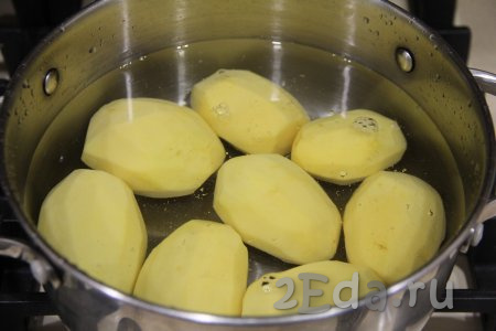 Картошку почистить, переложить в кастрюлю, полностью залить водой и отправить на огонь. Воду после закипания подсолить и варить картошины на небольшом огне в течение 7-8 минут (до полуготовности). Затем отвар слить, дать картофелинам немного остыть.