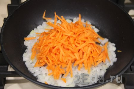 К обжаренному луку выложить морковку, натёртую на крупной тёрке, перемешать и обжаривать 4-5 минут, не забывая овощи иногда перемешивать.