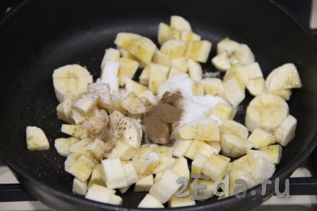 Бананы очистить и нарезать на небольшие кусочки, выложить на сковороду, добавить сахар и корицу, поставить на средний огонь.