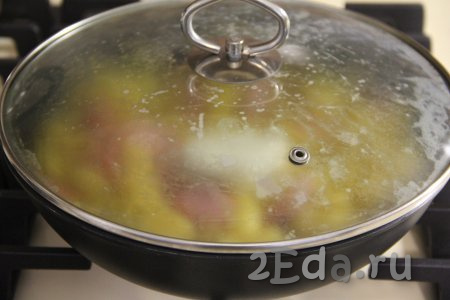 Накрыть сковороду крышкой, готовить макароны с сосисками с момента закипания на медленном огне до полного испарения воды (на это потребуется минут 15).