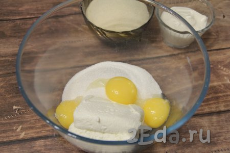 Разделить аккуратно яйца на желтки и белки (убрать белки в холодильник). В миске соединить творог, сахар, желтки и ванильный сахар.