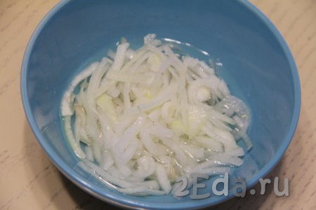 Нарезать очищенную луковицу на тонкие полукольца, переложить в глубокую тарелку, сюда же влить 2 столовых ложки воды, добавить уксус и сахар, перемешать и оставить мариноваться на 15 минут.