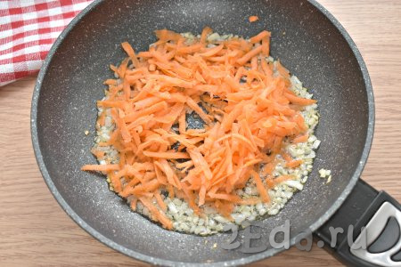 Натираем морковку на крупной тёрке и перекладываем её к мягкому луку, обжариваем овощи вместе 4-5 минут (до мягкости морковки).