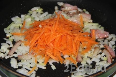 Морковь очистить, натереть на крупной тёрке, выложить на сковороду с колбасой и луком, обжарить в течение 3-5 минут, иногда помешивая.