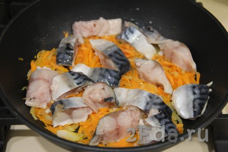Выложить кусочки скумбрии на обжаренные овощи. Обжарить рыбку с овощами 2-3 минуты.
