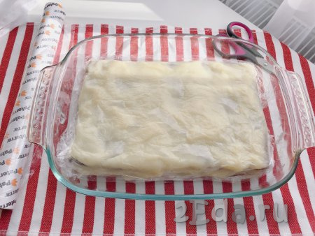 Теперь последний слой крема накрываем пищевой плёнкой так, чтобы плёнка плотно прилегала к крему по всей поверхности формы (это нужно для того, чтобы верхний слой не заветрился, пока десерт будет остывать). Убираем десерт из печенья и заварного крема в холодильник до полного остывания крема (примерно на 30-40 минут).