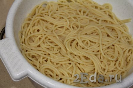 Отваренные спагетти откинуть на дуршлаг, промыть проточной холодной водой, дать лишней жидкости стечь.