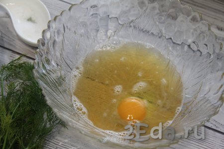 В миску влить пиво и 1 столовую ложку растительного масла, вбить сырое яйцо, перемешать венчиком.