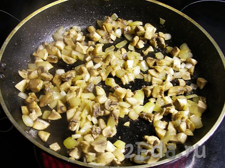 Теперь приготовим курино-грибную начинку. Для этого очищаем лук, ополаскиваем водой и нарезаем на кубики среднего размера. Шампиньоны моем, удаляем с них загрязнения и нарезаем на средние кубики. Можно использовать замороженные шампиньоны (или предварительно отваренные в течение 25-30 минут лесные грибы). Обжариваем лук с грибами на растительном масле, иногда помешивая, на среднем огне минут 10 (до испарения влаги из грибов). Если вы используете замороженные грибы, тогда их не нужно размораживать, но обжаривать их нужно будет минут 20.