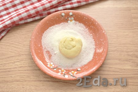 На тарелку насыпаем 2 столовых ложки сахара. Верх заготовок печенья обмакиваем в сахар. Для того чтобы сахар лучше прилипал, верхушку печенья можно немного смазать водой.