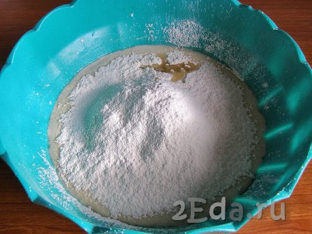 В воду с сахаром и дрожжами добавляем соль и 2 столовых ложки растительного масла, начинаем частями всыпать просеянную муку, перемешивая вначале тесто ложкой.