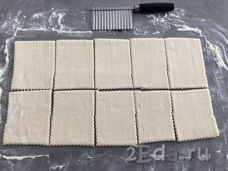 Нарезать тесто на прямоугольники размером приблизительно 10х6 сантиметров. У меня получилось 10 штук. Нарезала я фигурным ножом для сыра, чтобы получились ажурные края. Вы можете нарезать тесто обычным ножом.