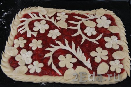 Из оставшейся части теста сделать украшение для пирога (я вырезала цветочки и листики с помощью вырубки для печенья). Вырезанные украшения выложить поверх начинки. Для того чтобы бортики пирога были более интересными, можно сделать на них надрезы.  