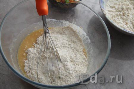 Добавить в миску соль. Муку просеять и начать небольшими частями всыпать в миску, перемешивая тесто для кулича вначале венчиком.