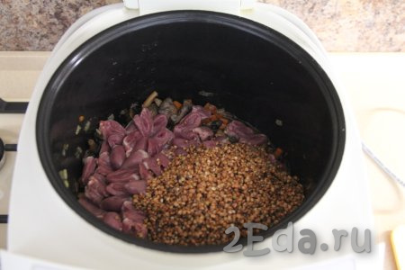Гречку промыть водой, убирая испорченные зёрна, после этого дать стечь воде. Добавить подготовленную крупу в чашу мультиварки к сердечкам и овощам.