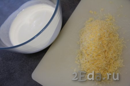 Влить кефир в миску, в которой будете замешивать тесто, добавить соду, перемешать и оставить минут на 5 (за это время сода погасится в кефире). Сыр натереть на мелкой тёрке.