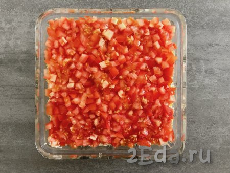 Последним слоем выкладываем помидоры, нарезанные на небольшие кубики. Для приданию блюду терпкого аромата помидоры я посыпала сверху сушёным орегано.