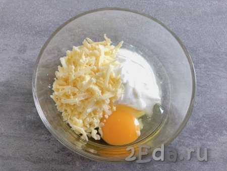 Для приготовления заливки в небольшой миске смешиваем сметану, сырое яйцо, 50 грамм натёртого на крупной тёрке сыра и соль, тщательно перемешиваем вилкой (или венчиком).