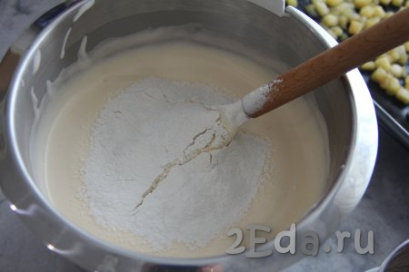 Добавить разрыхлитель и соль, небольшими порциями начать всыпать просеянную муку, каждый раз движениями лопатки снизу вверх, полностью вмешивая её в тесто для бисквитного коржа.