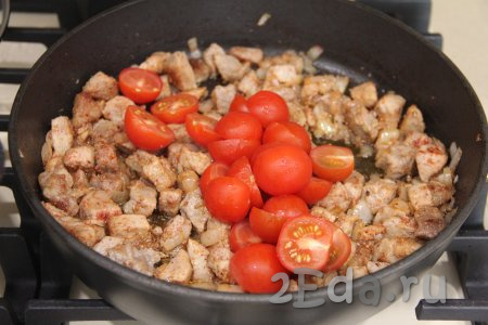 В сковороду с мясом добавить помидоры, нарезанные на кусочки. У меня были помидоры черри, я их нарезала на половинки. Перемешать помидоры и мясо.