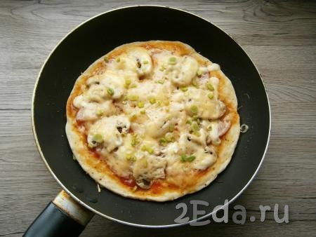Поставить сковороду на небольшой огонь, накрыть крышкой. Готовить ленивую пиццу около 10 минут, затем посыпать измельченным зеленым луком.