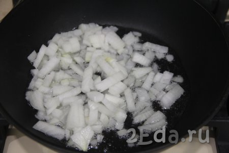 Как только гороховый суп с фаршем закипит, добавить картошку, ещё раз дать закипеть, а после этого на небольшом огне варить ориентировочно минут 15 (до мягкости картошки). Пока варится картофель, обжарим овощи. Для этого в сковороде нужно прогреть немного растительного масла, а затем выложить достаточно мелко нарезанный лук, обжарить его на среднем огне минуты 2, помешивая.