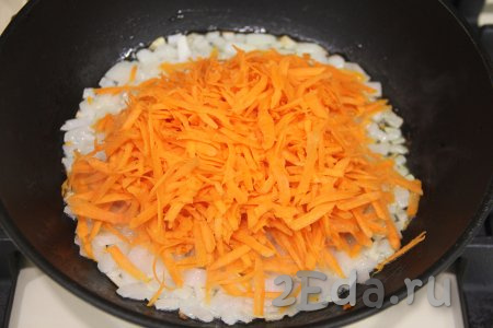 К слегка обжаренному луку выложить натёртую на крупной тёрке морковку, перемешать.