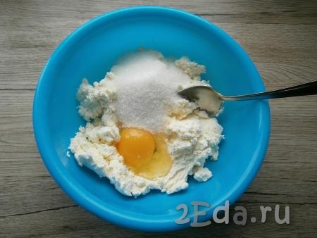 Для приготовления начинки в мягкий творог добавить сырое яйцо, всыпать сахар.