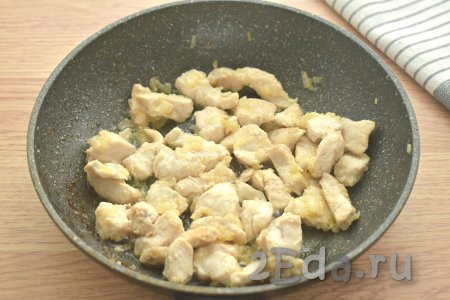 Обжариваем кусочки куриного мяса с луком 8-10 минут, иногда помешивая.