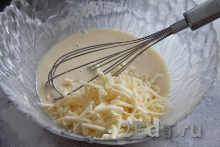 Перемешать массу венчиком и добавить натёртый на крупной тёрке сыр.