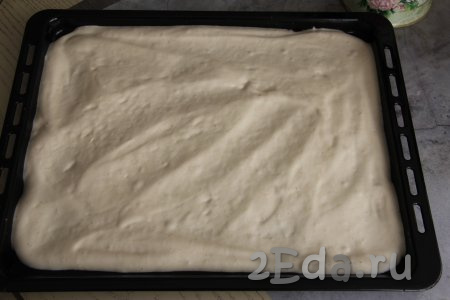 Противень (у меня противень размером 50 сантиметров на 45 сантиметров) застелить пергаментом (или ковриком для выпечки), выложить тесто, равномерно распределить его при помощи лопатки по застеленному противню.