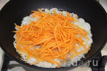 Морковь натереть на тёрке для корейской моркови (или на крупной тёрке) и добавить к луку, перемешать. Обжаривать овощи, иногда помешивая, в течение 5 минут.