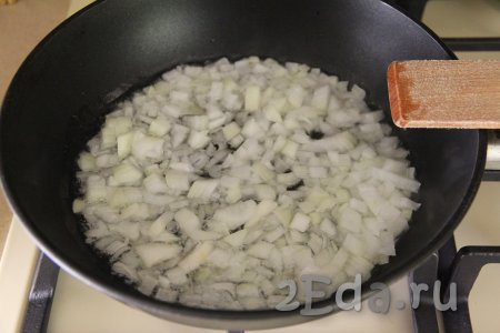 В сковороде прогреть растительное масло, выложить мелко нарезанный лук и обжарить его на среднем огне, периодически перемешивая, в течение 3-4 минут (до прозрачности).