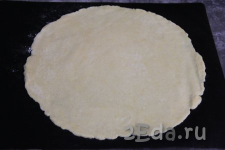 На противне, застеленном ковриком (или пергаментом) для выпечки раскатать песочное тесто в круг диаметром примерно 30 сантиметров.