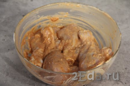 Перемешать куриные ножки, покрывая их солью, чесноком, сметаной, кетчупом со всех сторон, и оставить промариноваться минут на 30.