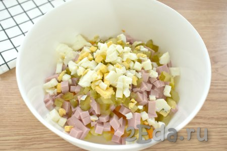 Яйца тоже нарезаем на маленькие кубики, выкладываем в миску с салатом. Для того чтобы "Оливье" получился вкусным, желательно, чтобы ингредиенты были нарезаны на кубики одинакового размера.