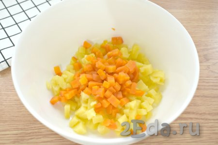 Тщательно моем, а затем отвариваем в кожуре морковь и картошку до готовности (на варку картофеля потребуется минут 20-25 с момента закипания воды, морковку нужно будет варить 30-35 минут после начала кипения воды). Отвариваем вкрутую яйца (варим после закипания воды 10 минут). Даём варёным картошке, моркови и яйцам полостью остыть (я остужаю их под ледяной водой) и очищаем. Приступаем к приготовлению салата "Оливье", для этого картошку и морковку нарезаем на маленькие кубики (размером примерно 6-8 миллиметров), складываем в миску.