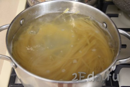 В кастрюлю с кипящей подсоленной водой выложить спагетти, перемешать, дать закипеть и варить на небольшом огне до готовности (обычно на варку требуется минут 7-9, точное время варки посмотрите на упаковке макарон, которые вы готовите). Откинуть готовые спагетти на дуршлаг, чтобы стекла лишняя вода.