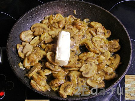 Снимаем сковороду с огня, добавляем в обжаренные грибы с луком кусочек сливочного масла и перемешиваем, пока масло не растает. Оставляем немного остыть.