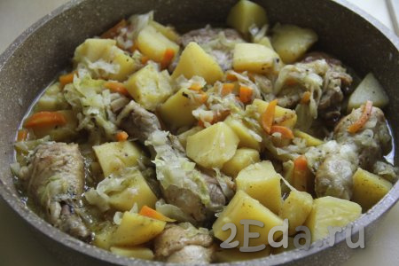 Довести воду до кипения, уменьшить огонь до минимума, накрыть сковороду крышкой. Тушить курицу с картошкой и капустой минут 25-30 (до мягкости картофеля и капусты).