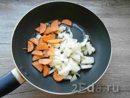 Морковь и лук очистить. Лук нарезать произвольными кусочками, морковь - полукружочками, выложить их на сковороду, разогретую с 2 столовыми ложками растительного масла.