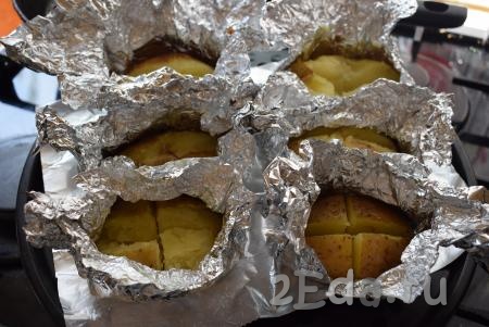 Достаем запеченную картошку из духовки, разворачиваем фольгу, открывая картошку, ставим ее обратно в духовку, для того чтобы картофель подрумянился.