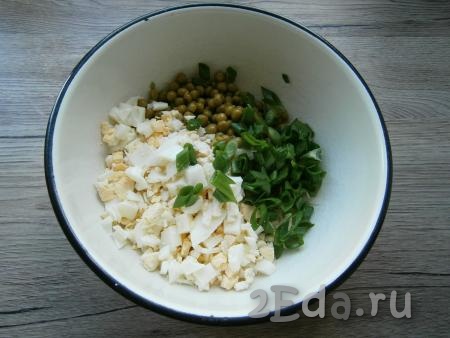 В салат из капусты и горошка добавить рубленные вареные яйца и нарезанный зеленый лук.