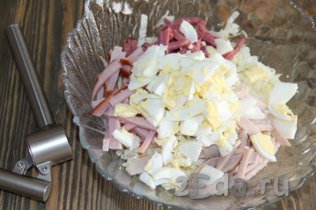 Яйца, нарезанные не очень мелко, и пропущенный через пресс чеснок выложить в салат из мяса и пекинской капусты, хорошо перемешать.